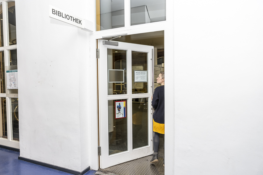 Bibliothek, Bibliothekseingang, Schild der Bibliothek, Person betritt